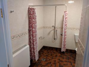 a bathroom with a shower with red and white curtains at Mellwaters Barn Cottages in Bowes +50 photos