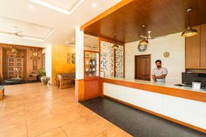 
a man standing in a kitchen next to a counter at Winter Vale Green Stay Resorts in Vagamon
