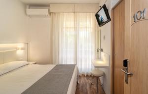 a hotel room with a bed and a window at Hotel Hermitage in Marina di Massa