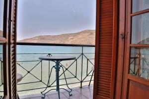 a balcony with a table and a view of the ocean at Guesthouse Palataki in Neon Oitilon