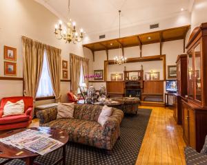 a living room with a couch and a table at Courtyard Hotel Arcadia in Pretoria