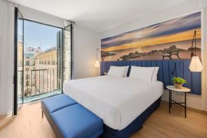 a hotel room with a bed, chair, and table at Eurostars Mediterranea Plaza in Alicante