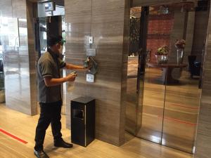 a man standing in front of a door with a cell phone at Swiss-Belhotel Airport Jakarta in Tangerang