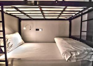 a bedroom with a bunk bed with white sheets at The Blocks Hostel Sukhumvit 10 in Bangkok