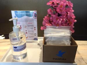 a bottle of hand sanitizer and a box of flowers at Swiss-Belhotel Airport Jakarta in Tangerang
