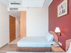A bed or beds in a room at Hotel Bulevar Tanjung Duren Jakarta