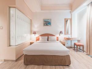 A bed or beds in a room at Hotel Bulevar Tanjung Duren Jakarta