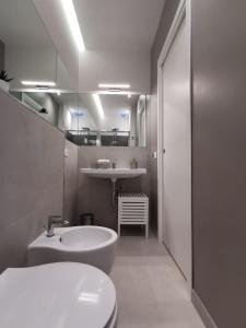 a bathroom with a sink and a toilet and a mirror at Via Vittorio Emanuele Apartment in Palermo