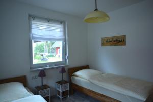 1 Schlafzimmer mit 2 Betten und einem Fenster in der Unterkunft Urlaub am Plätlinsee - Haus Odin in Wustrow