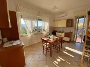 - une cuisine et une salle à manger avec une table et des chaises dans l'établissement Appartamento Villa Circe, à Taormine