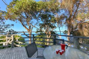 a glass table with red cups on top of a table at Jetty Road Retreat in Nungurner