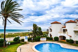 a villa with a swimming pool in front of the ocean at Playa del Sol - Primera Línea in Denia