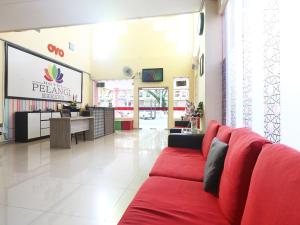 uma sala de estar com um sofá vermelho numa loja em Super OYO 89640 Hotel Pelangi Marang em Marang