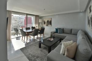 uma sala de estar com um sofá e uma mesa em Le Yacht Suites Hotel em Casablanca