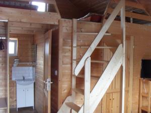 una escalera en una cabaña de madera con baño en Domki Letniskowe Marzena, en Międzyzdroje