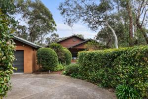 a house with a garage and some bushes at Mountain Home Leura - Perfect Weekend Escape in Leura
