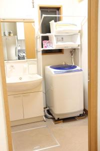 een badkamer met een wastafel en een wasmachine bij MIKOTO HOUSE in Kashū