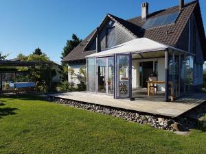 ein Haus mit Glastüren und einer Holzterrasse in der Unterkunft BnB Seaview in Kesswil