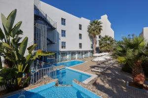 a hotel with a swimming pool next to a building at Pollis Hotel in Hersonissos