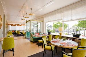 une salle à manger avec des tables et des chaises jaunes dans l'établissement Hotel Reutemann-Seegarten, à Lindau
