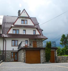 a large white house with a garage at Hawrań Bukowina in Bukowina Tatrzańska