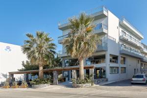 a building with palm trees in front of it at Pollis Hotel in Hersonissos