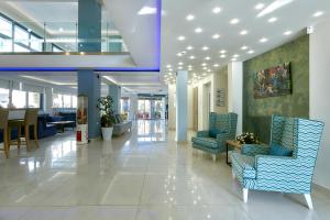 a lobby with chairs and tables in a building at Pollis Hotel in Hersonissos