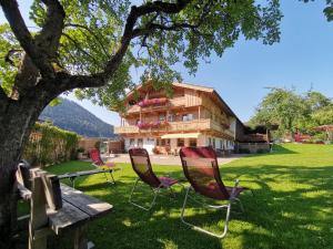 eine Bank und Stühle vor einem Gebäude in der Unterkunft Ferienhof Haindlbauer in Kirchberg in Tirol