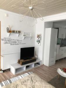 een woonkamer met een tv aan een witte muur bij Gäste-Apartment "Carpe Diem" in Osterburg