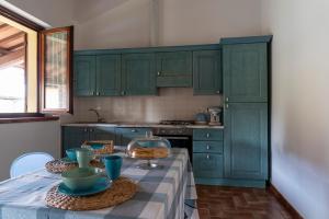 a kitchen with green cabinets and a table with dishes at Ca' Masini in San Giovanni in Marignano