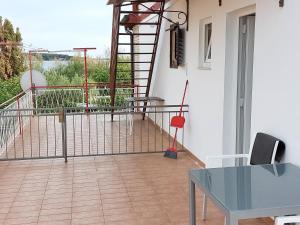 Habitación con balcón con escalera y mesa. en Guest House Nina, en Novigrad Istria