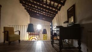 Habitación con balcón con silla y piano. en Masia Can Bachs, en Sant Pere de Vilamajor