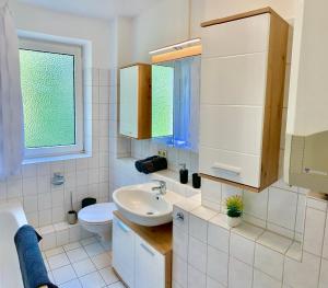 a bathroom with a sink and a toilet and a window at Classic Kian in Hannover