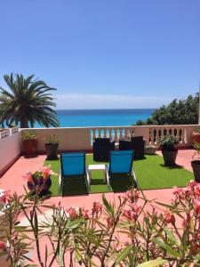 a patio with chairs and the ocean in the background at Hotel Cresp in Nice