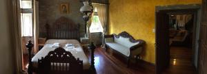 - une chambre avec un lit, un canapé et une chaise dans l'établissement O Pazo da Briona, à Arzúa