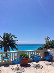 um grupo de cadeiras sentadas numa varanda com vista para o oceano em Hotel Cresp em Nice