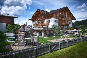 ein großes Holzhaus mit einem Spielplatz davor in der Unterkunft Rainerhof in Flachau