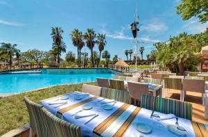 a table with a blue table cloth next to a swimming pool at Cambrils Park Family Resort in Cambrils