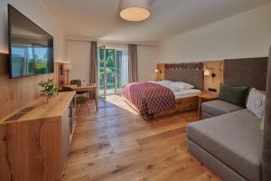 um quarto de hotel com uma cama e um sofá em RelaxResort Kothmühle em Neuhofen an der Ybbs