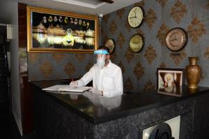 a man with a face mask sitting at a desk at Hotel 49 in Amritsar