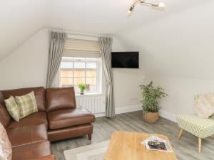 uma sala de estar com um sofá e uma mesa em The Loft em Hereford