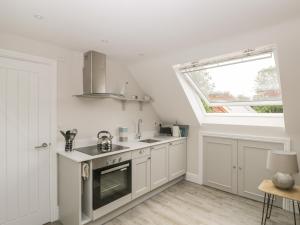 a kitchen with white cabinets and a window at The Loft in Hereford