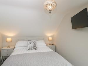 a bedroom with a white bed and a tv at The Loft in Hereford