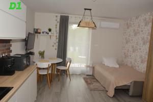 a small room with a bed and a table with chairs at Apartamenty Homole in Szczawnica