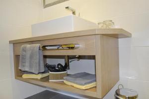 - une étagère en bois avec des serviettes et un lavabo dans la salle de bains dans l'établissement Ferienwohnungen Anja, à Steeg