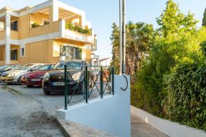 a building with cars parked in a parking lot at Ifigeneia apartment in Alepou