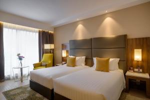 a hotel room with a large bed with yellow pillows at Crowne Plaza Nairobi Airport by IHG in Nairobi