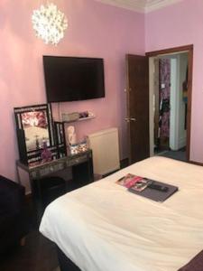 a bedroom with a bed and a tv on the wall at Sutton Park Guest House in Blackpool