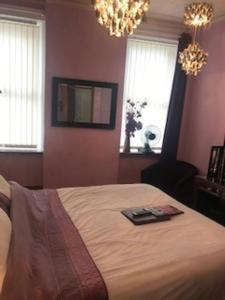 a bedroom with a bed and a chandelier at Sutton Park Guest House in Blackpool