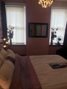 a bedroom with a large bed and a chandelier at Sutton Park Guest House in Blackpool